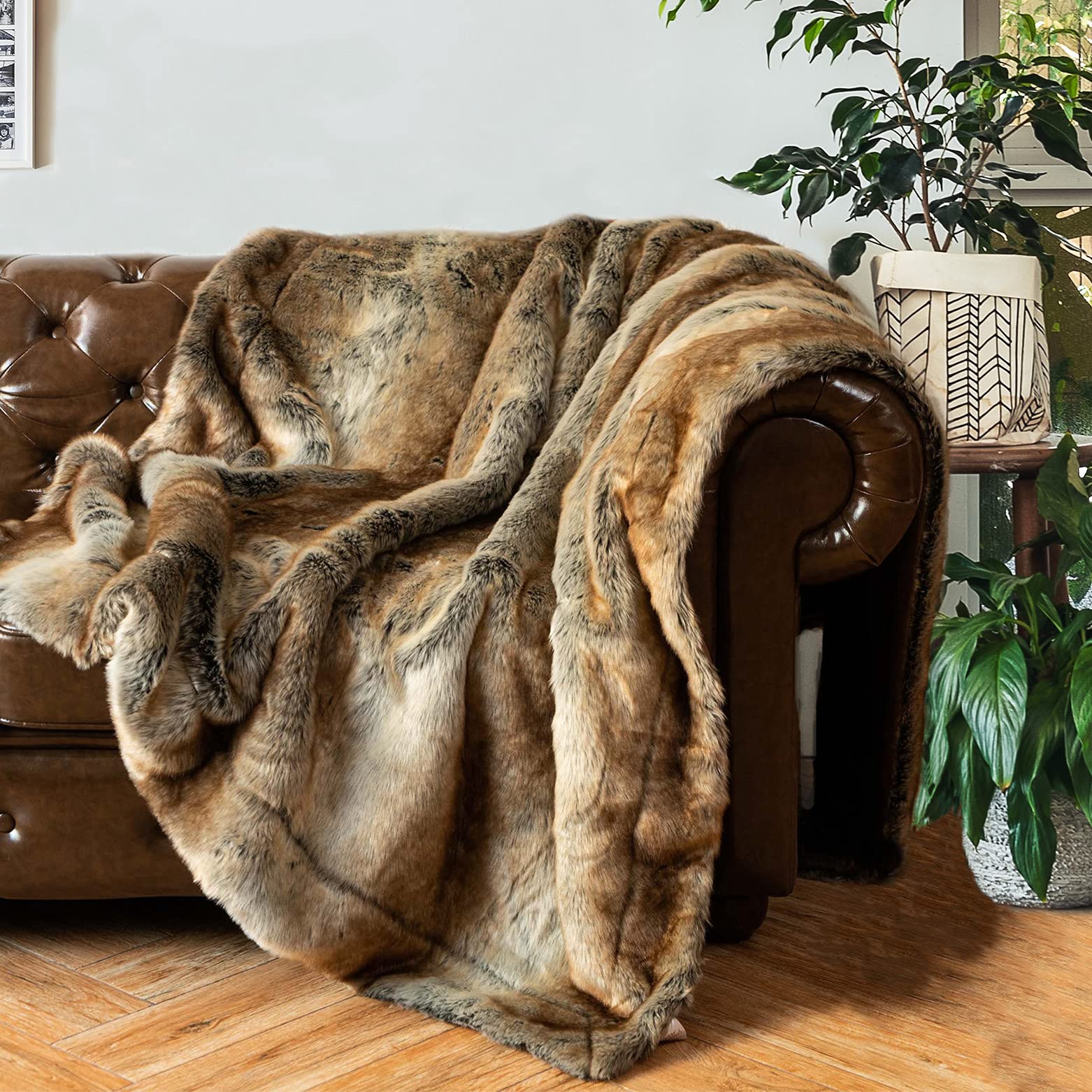 Brown faux fur throw blanket draped over a brown leather armchair in a home setting with plants.