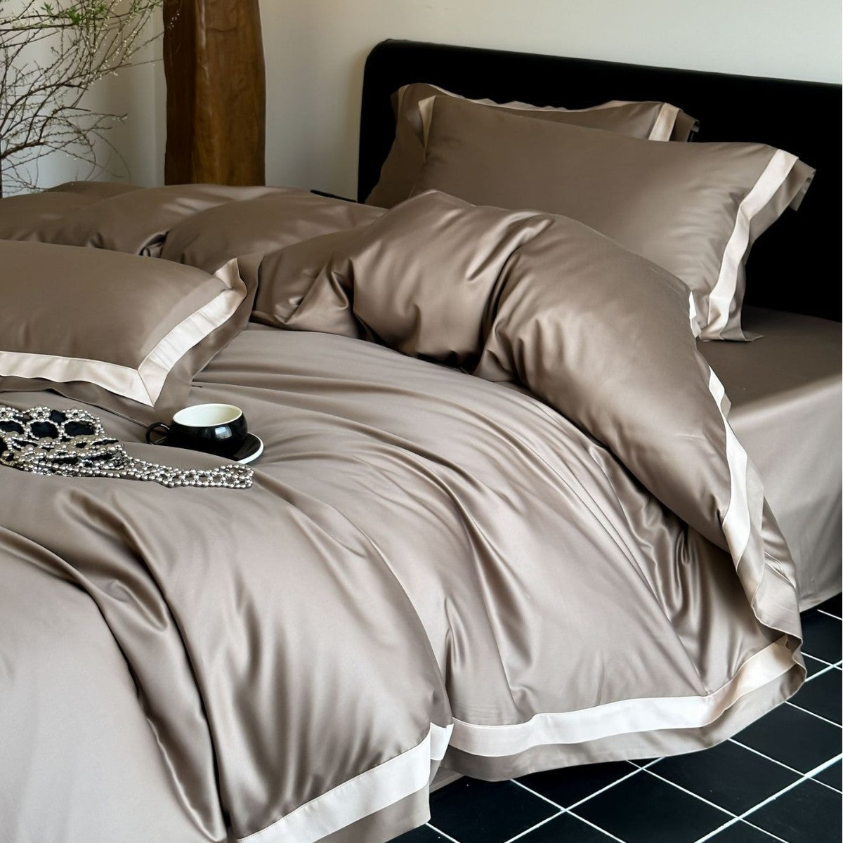 Neatly made bed with brown bedding in a bedroom setting.