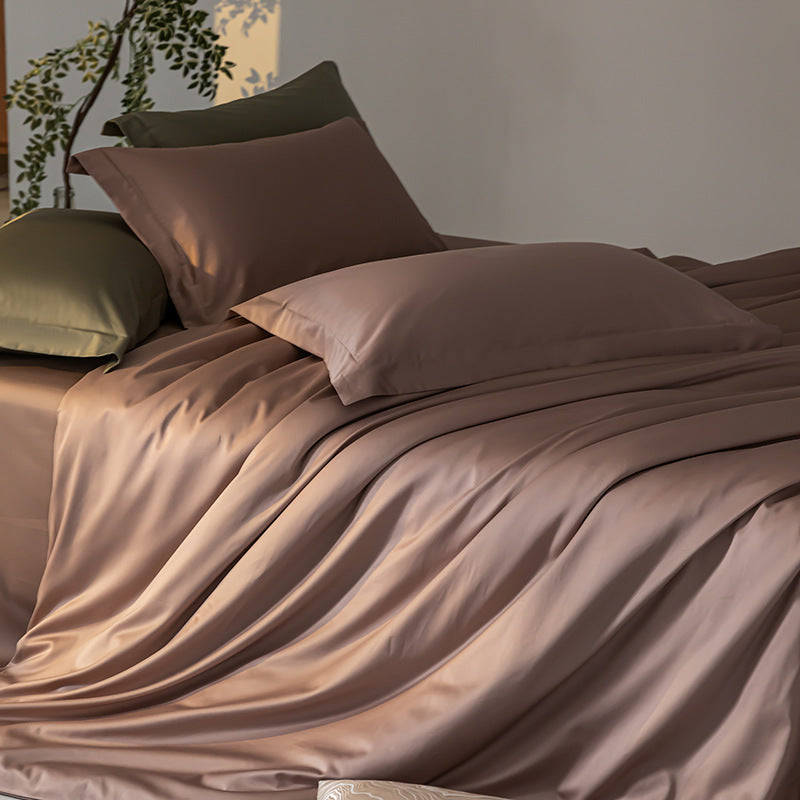 Brown satin bedding set with pillows on a bed