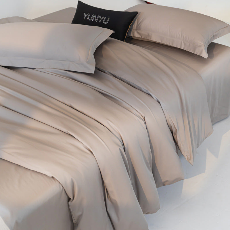 Beige bedding set with matching pillows on a bed, featuring the brand 'YUNYU'.