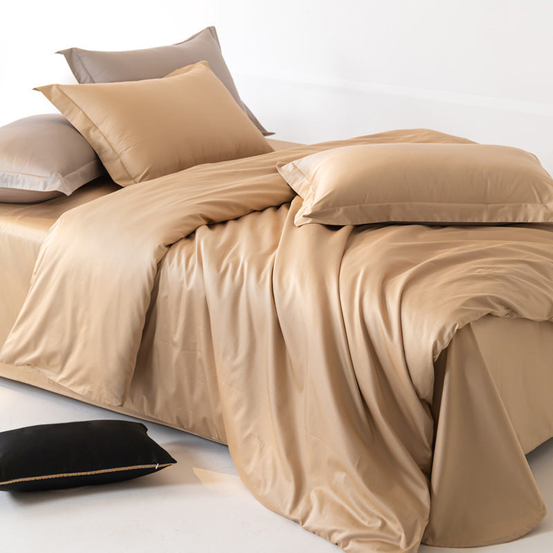 Beige bedding set with pillows on a bed against a white background