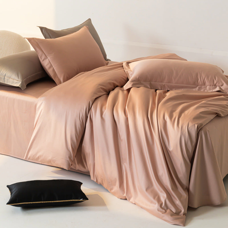 Beige bedding set on a bed with pillows against a white wall.