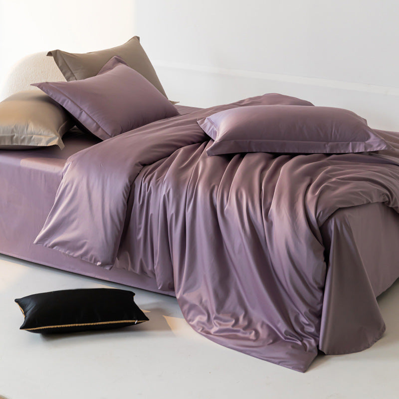 Purple bedding set on a bed with pillows in a minimalistic room.