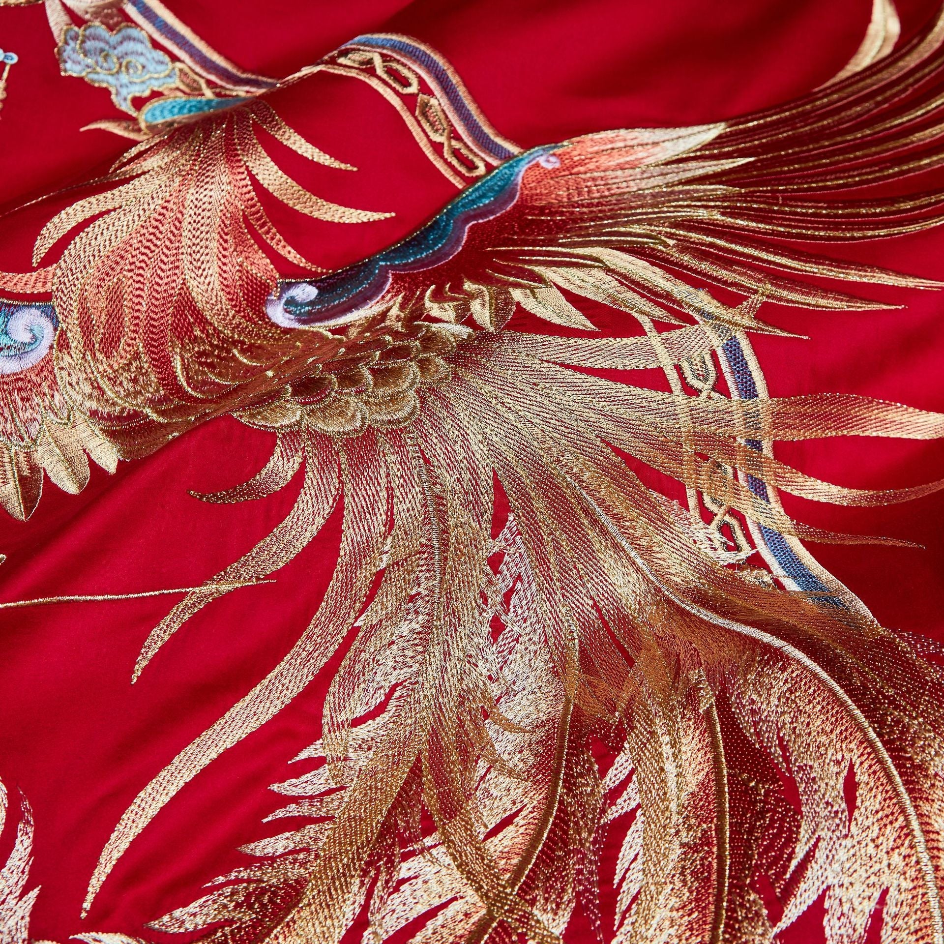 Embroidered gold phoenix on red fabric
