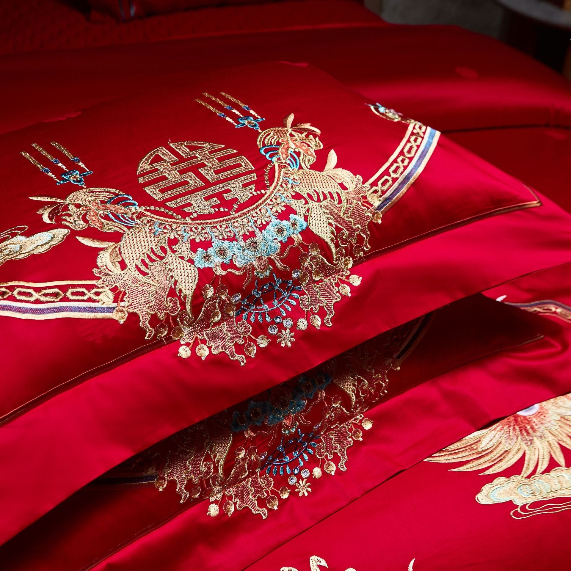 Red fabric with intricate gold embroidery featuring dragons and floral patterns.