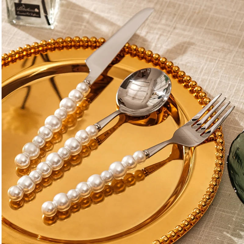 Decorative cutlery set with pearls on a gold plate