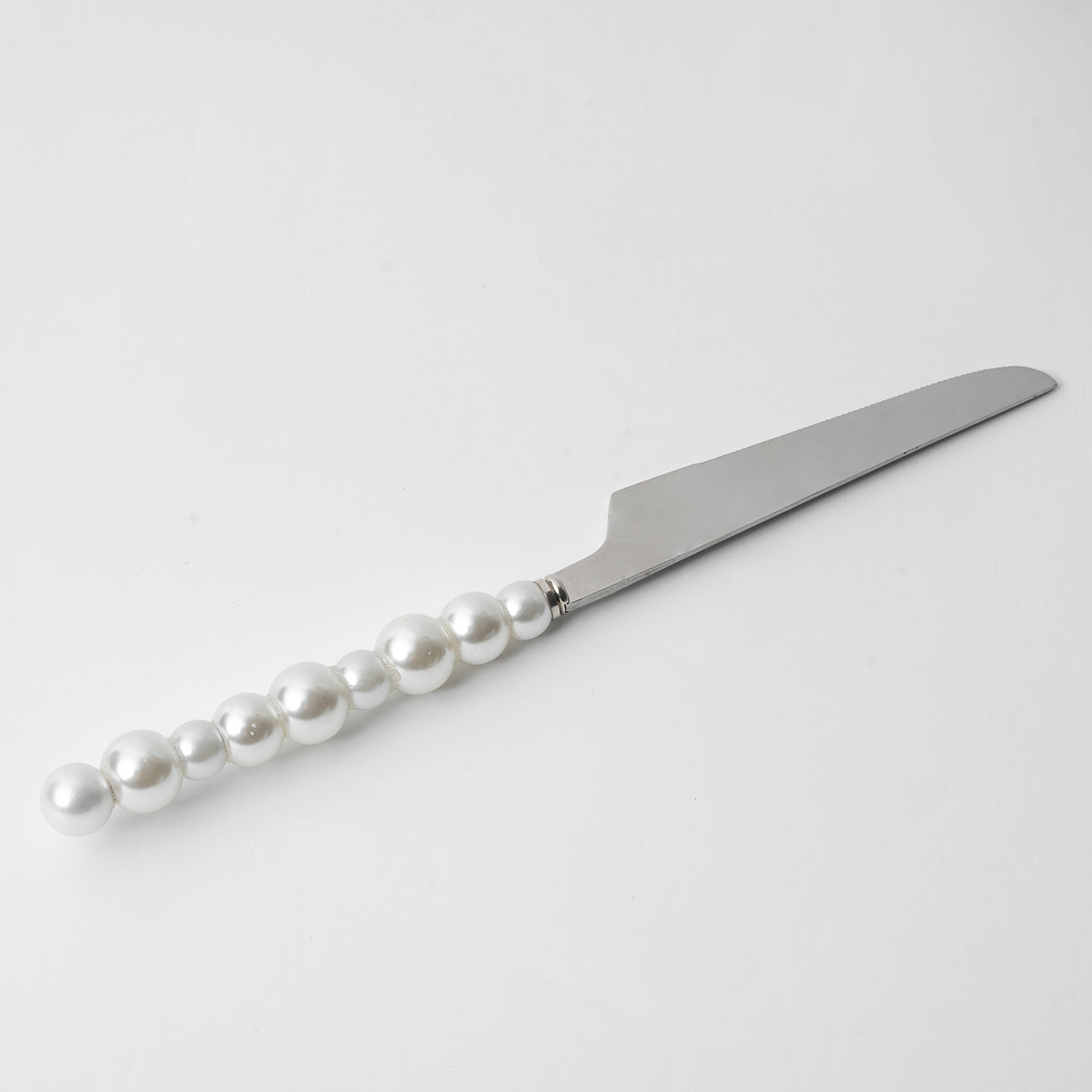 Silver cake knife with pearl handle on a white background