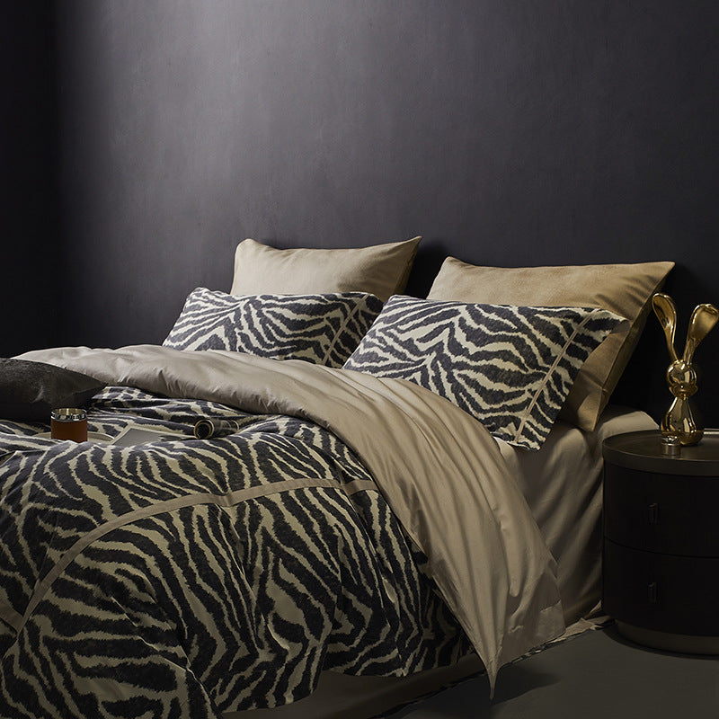 Bed with zebra print bedding and beige pillows against a dark wall.