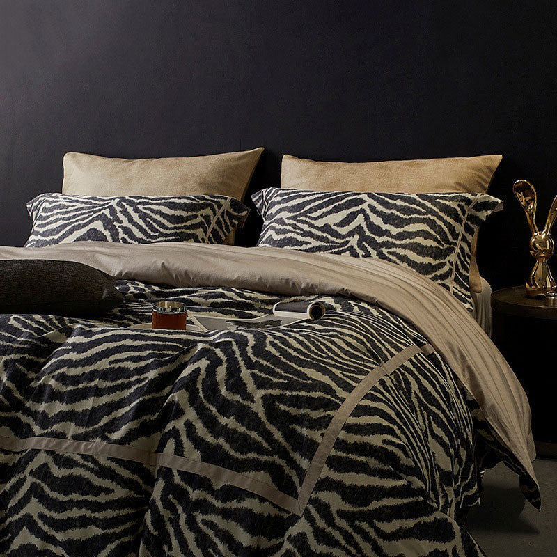 Bed with zebra print bedding against a dark wall