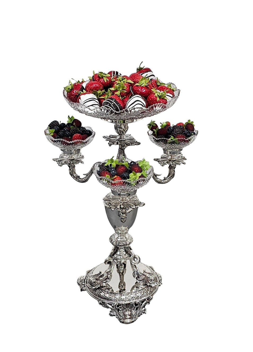 Decorative three-tiered fruit stand with strawberries, blackberries, and blueberries on a white background