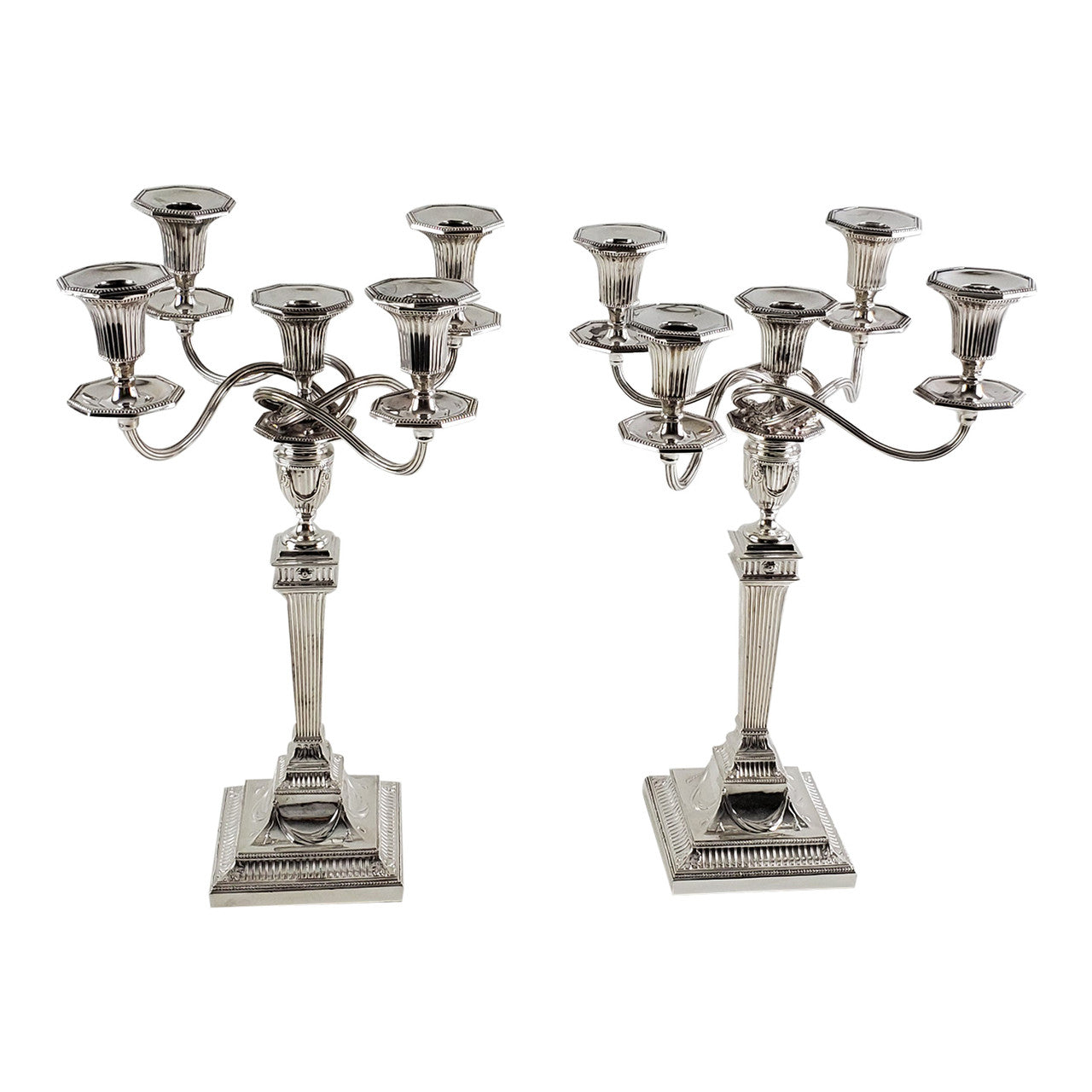 Two silver candelabras on a white background