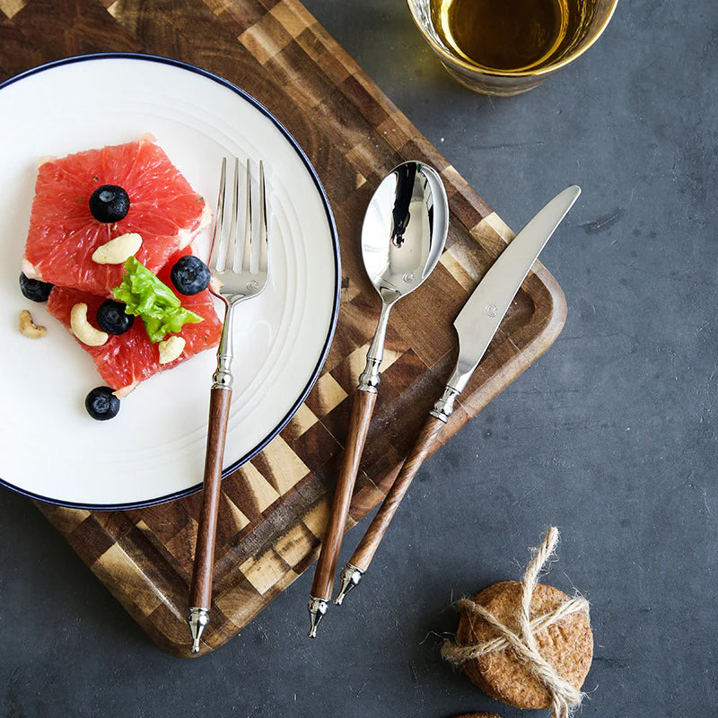 Plated dish with fruit salad on a wooden board with cutlery