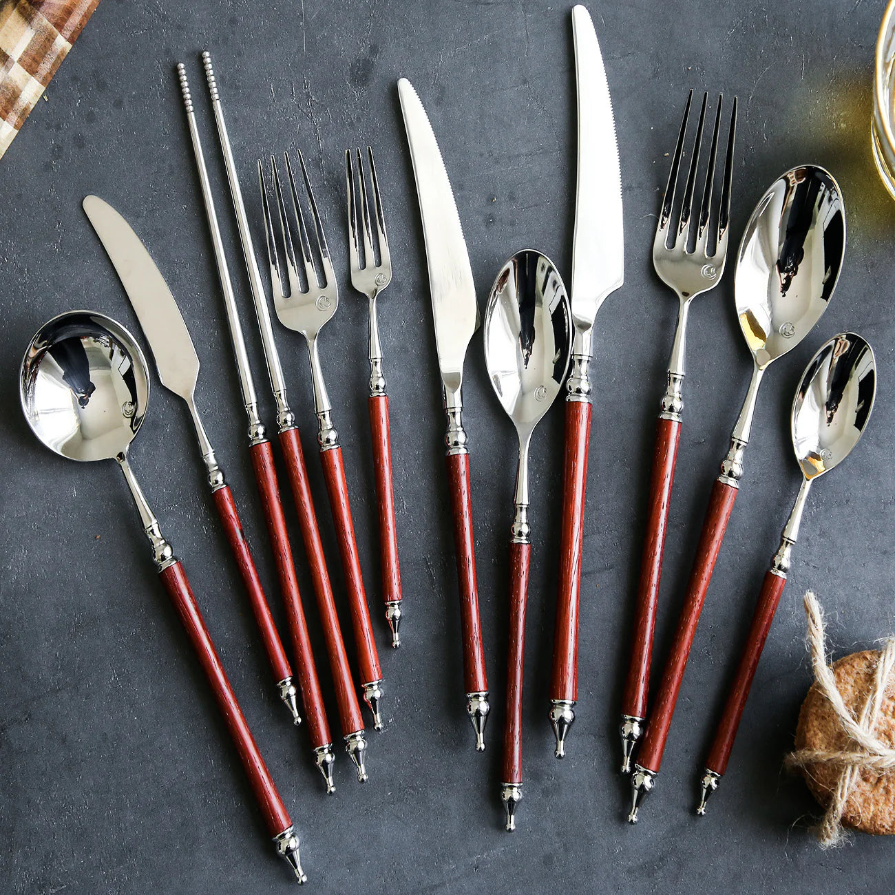 Set of silverware with red handles on a dark surface
