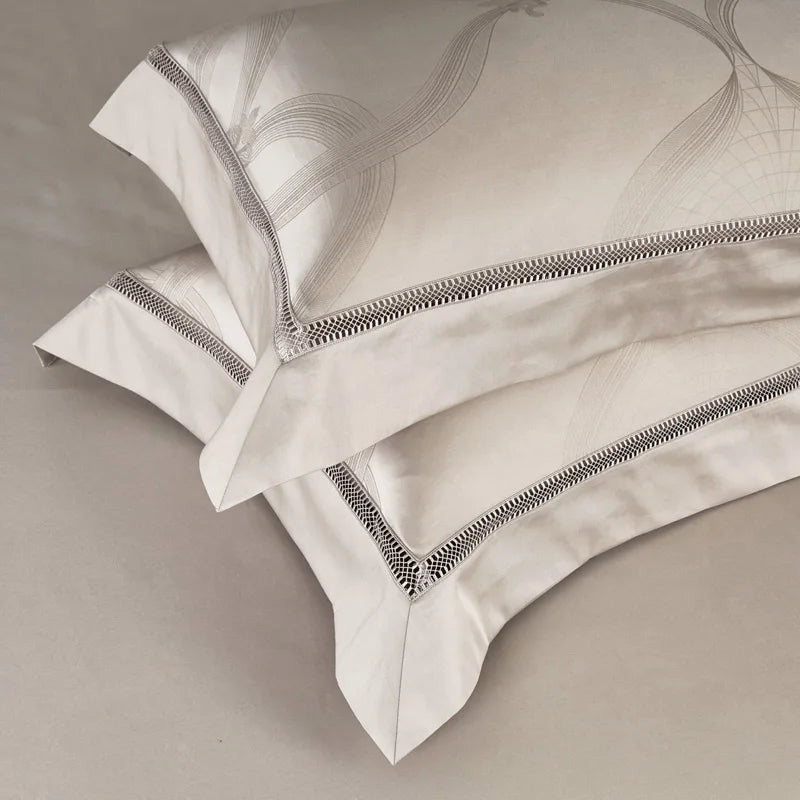 Two white pillows with decorative gray stitching on a beige background
