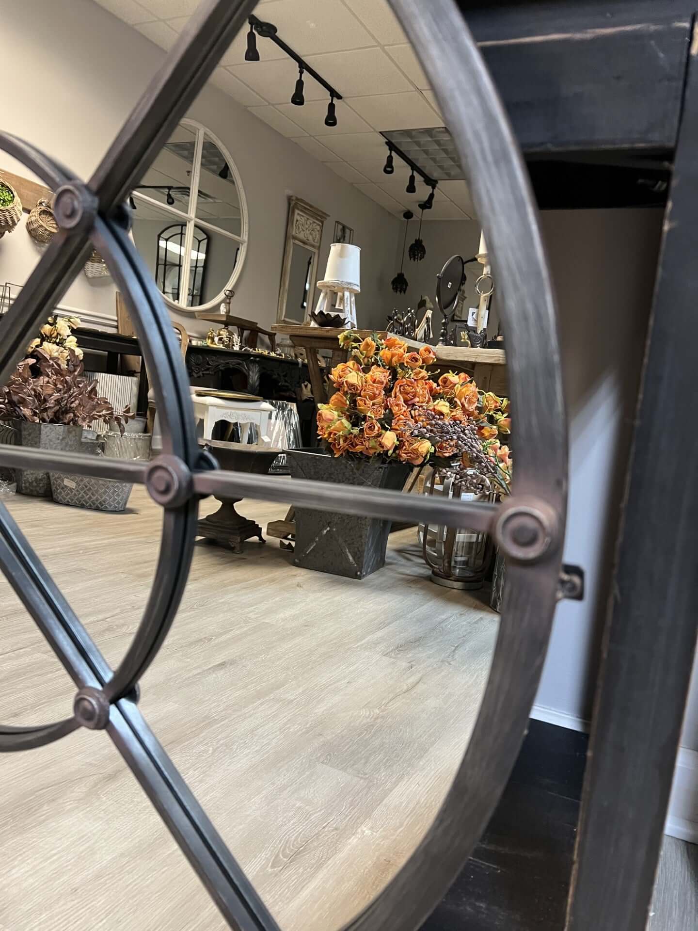 Decorative metal wheel with a blurred interior setting featuring furniture and decor.