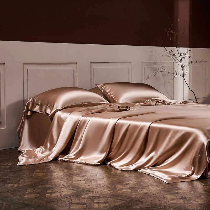 Silky satin bedding set on a bed with a neutral wall and wooden floor.