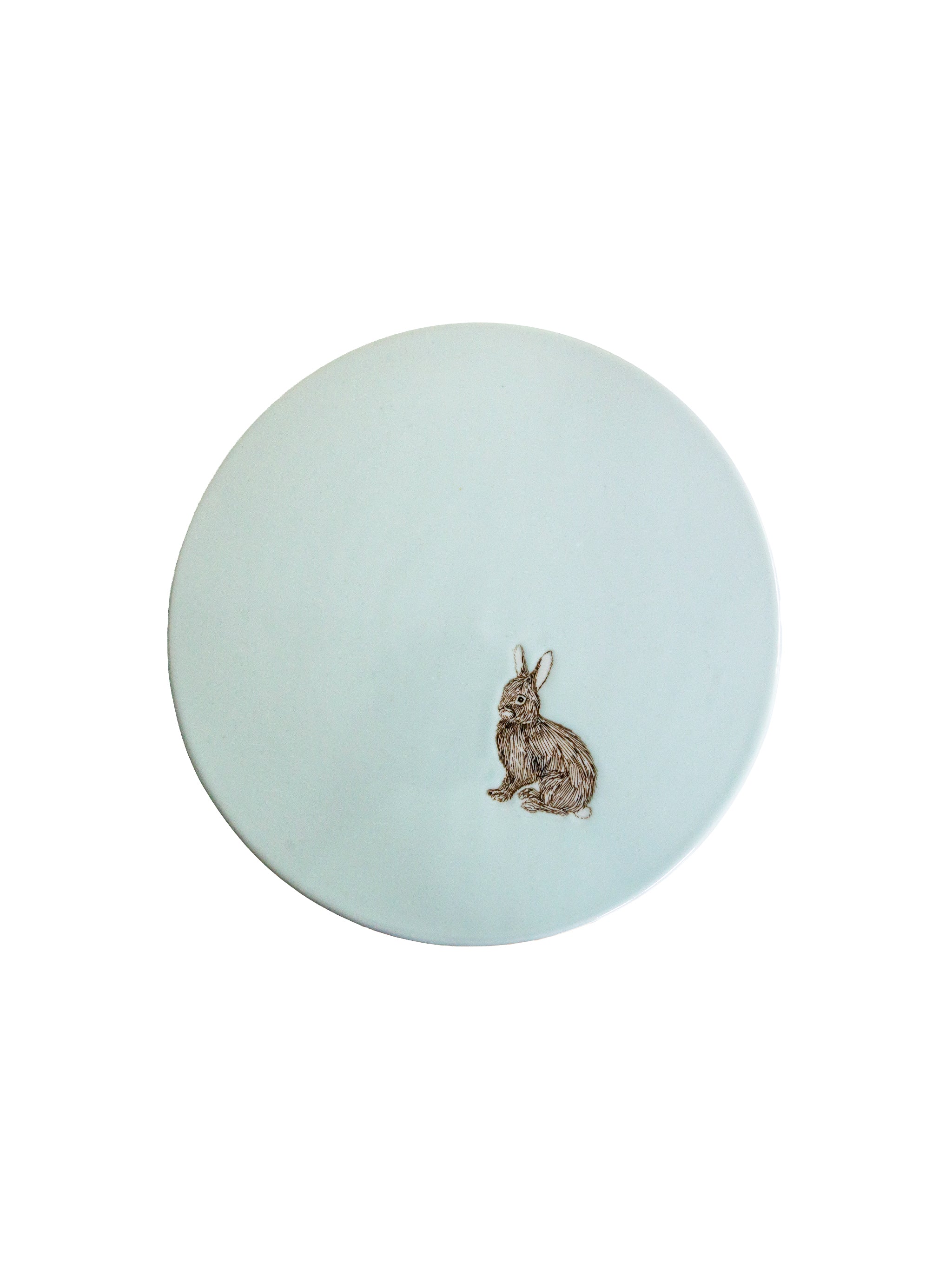 Round light blue cake stand seen from above with a rabbit design on a white background