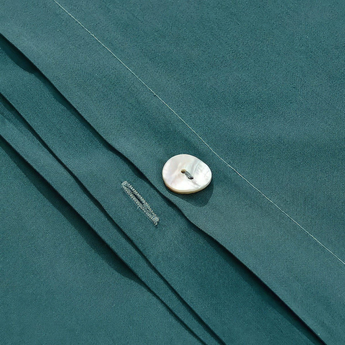 Close-up of a green fabric with a button and label detail