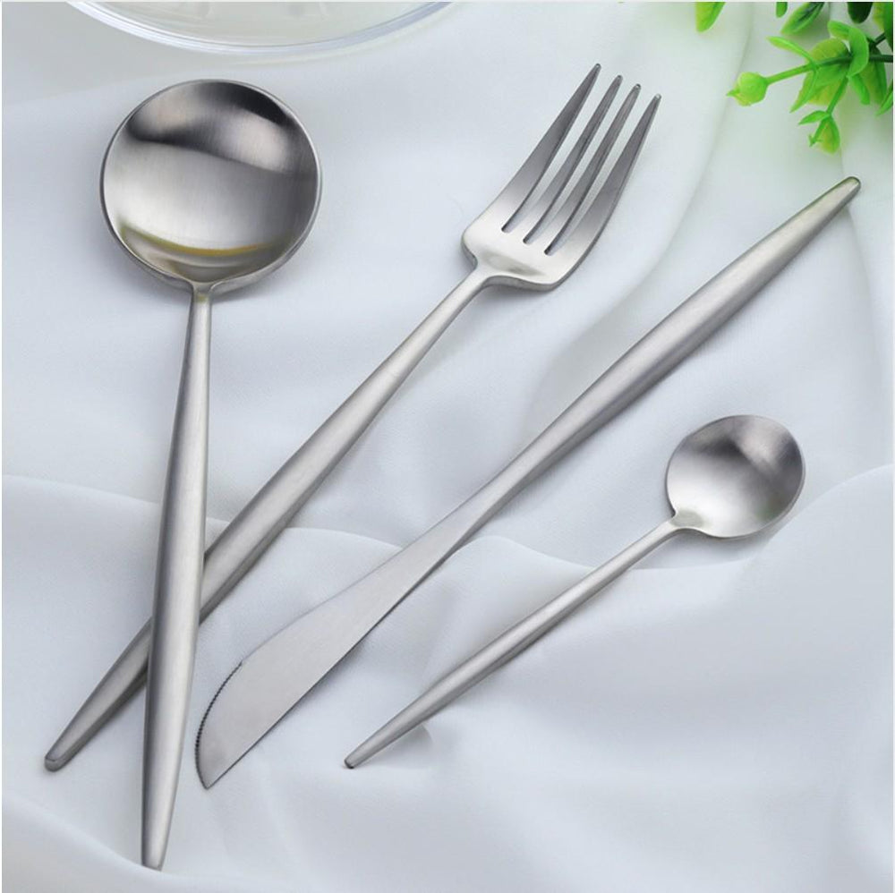 Set of stainless steel cutlery including a fork, knife, and two spoons on a white background.