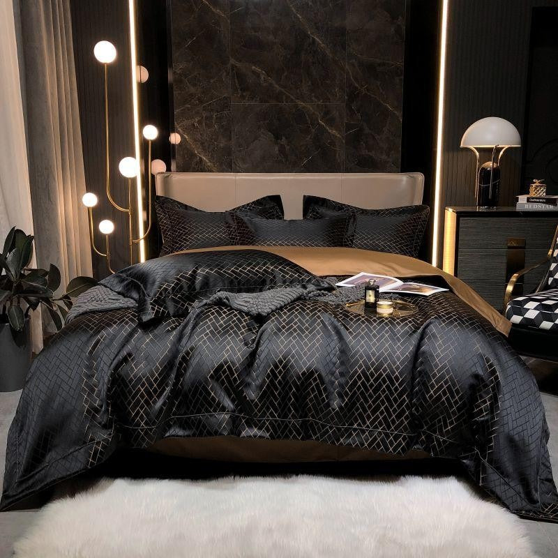 Luxurious bedroom with black quilted comforter and marble wall.