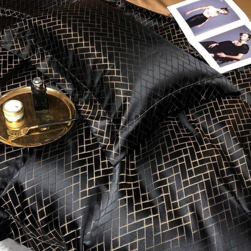 Black textured fabric with geometric pattern, possibly a dress or garment, on a surface.