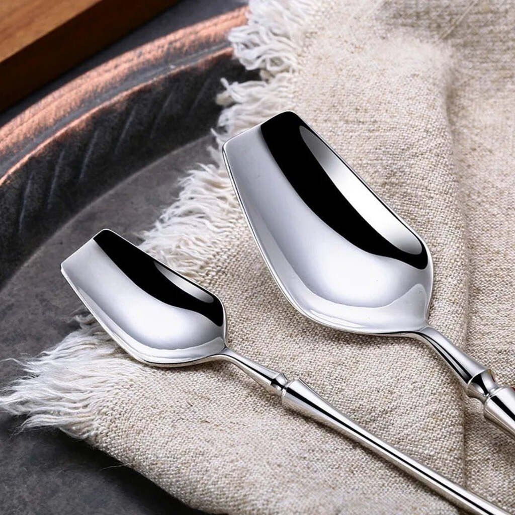 Two silver spoons on a textured fabric surface