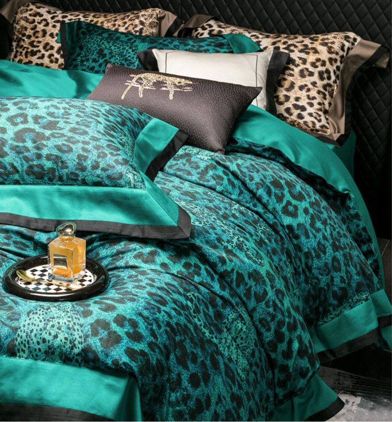 Teal leopard print bedding set with decorative pillows on a bed.
