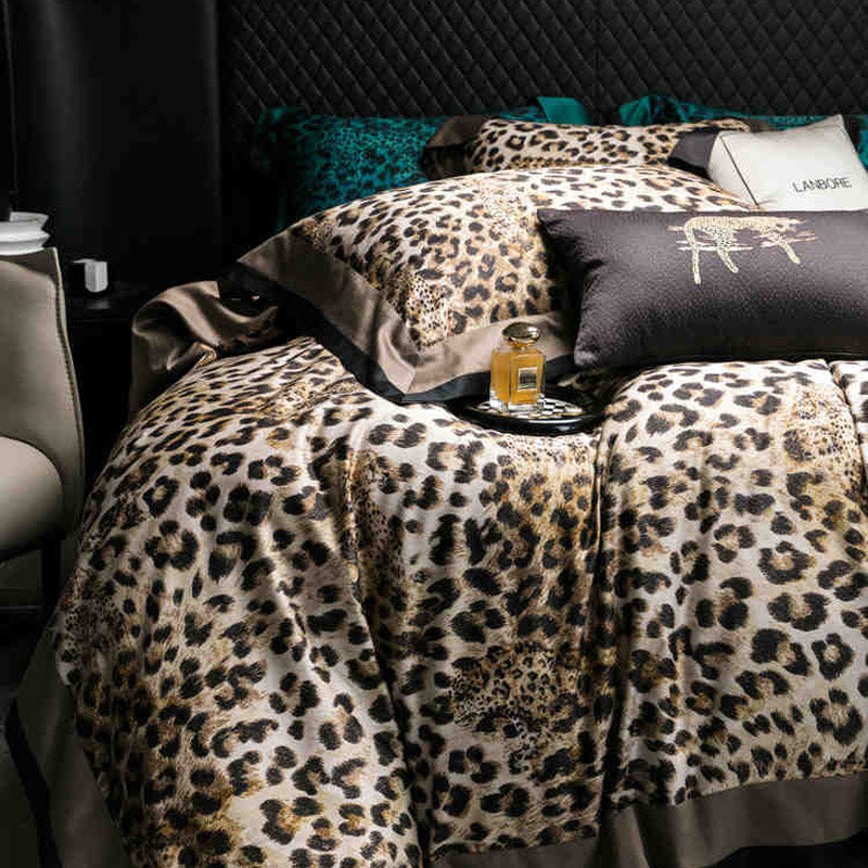 Bed with leopard print bedding and a bottle of perfume on a tray.