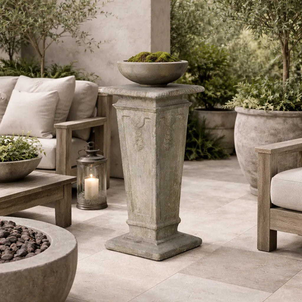 Outdoor patio setting with garden pedestal, furniture and decorative elements.