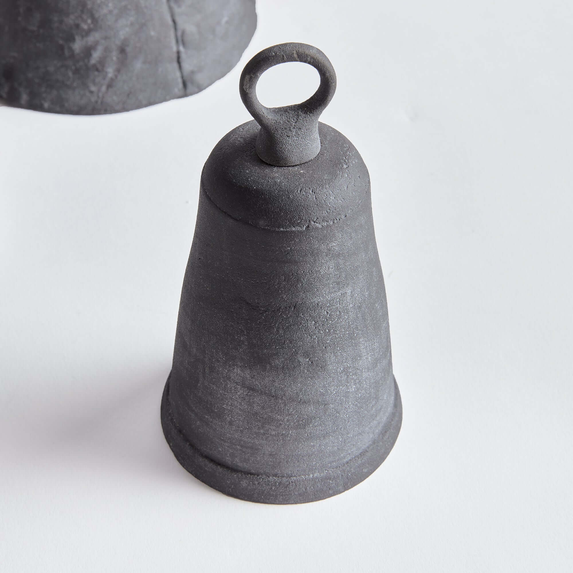 Black ceramic bell on a light gray background