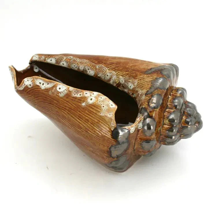 Wooden shell-shaped container with metallic accents on a white background