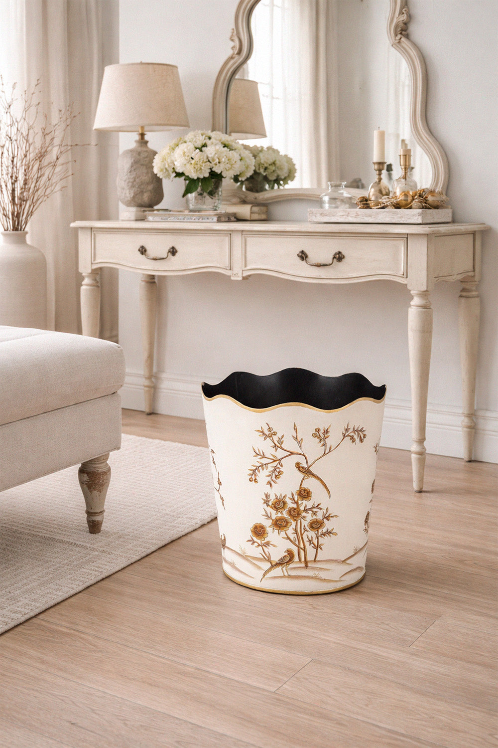 Decorative trash can with floral design on a wooden floor in a living room setting.