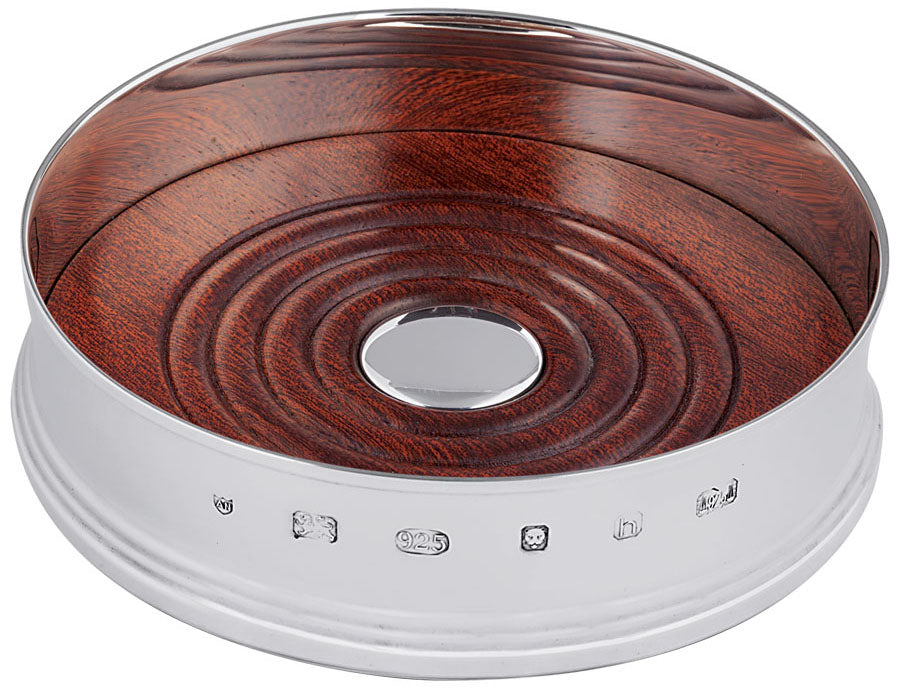 Round wooden object with a silver center on a white background