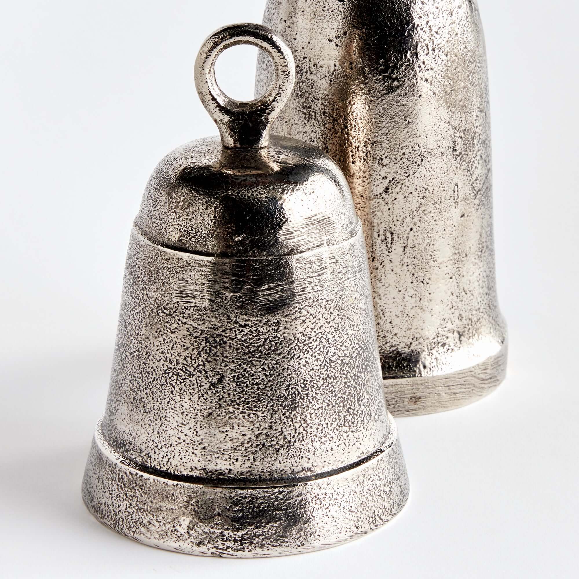 Two metallic bells on a white background