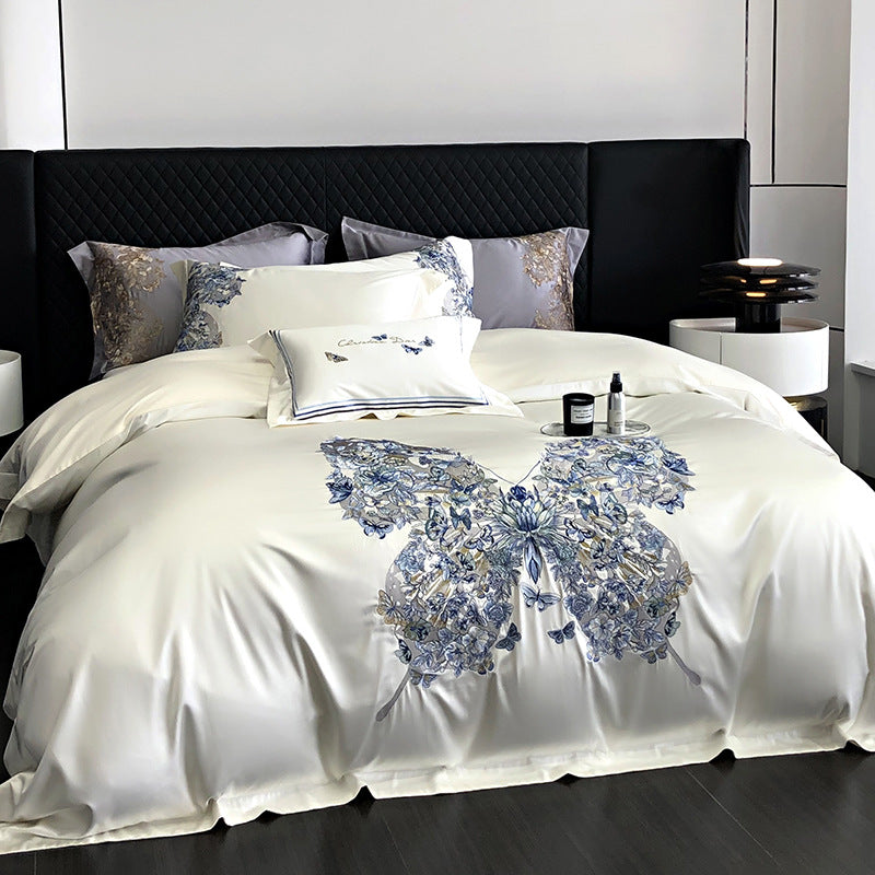 Bed with decorative bedding featuring a blue butterfly design in a bedroom setting.