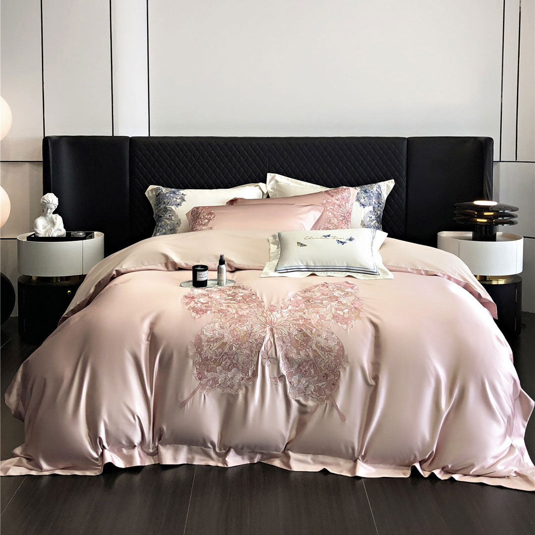 Pink butterfly patterned comforter on a bed in a modern bedroom setting