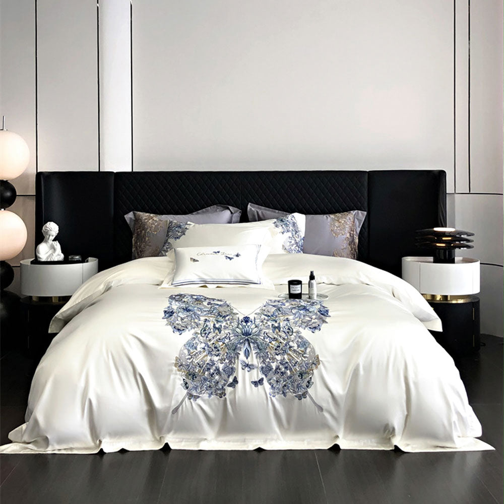 Bed with white bedding featuring a blue butterfly and floral design, set against a modern bedroom background.