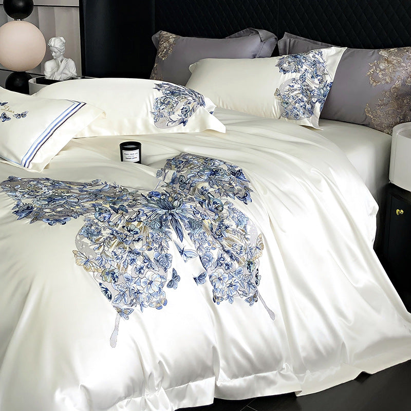 Butterfly and Floral patterned bedding set on a bed with decorative pillows and a nightstand.
