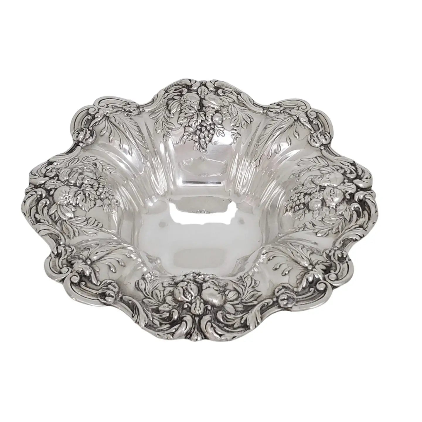 Decorative silver bowl with intricate floral and fruit patterns on a white background