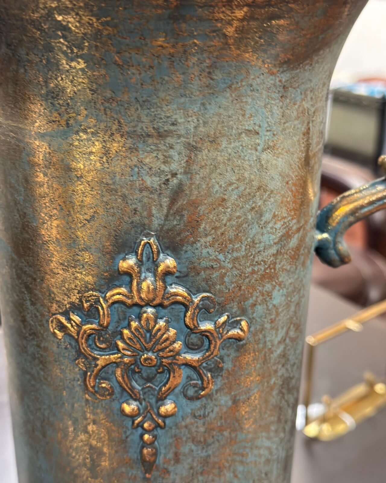 Close-up of a bronze vase with intricate floral design