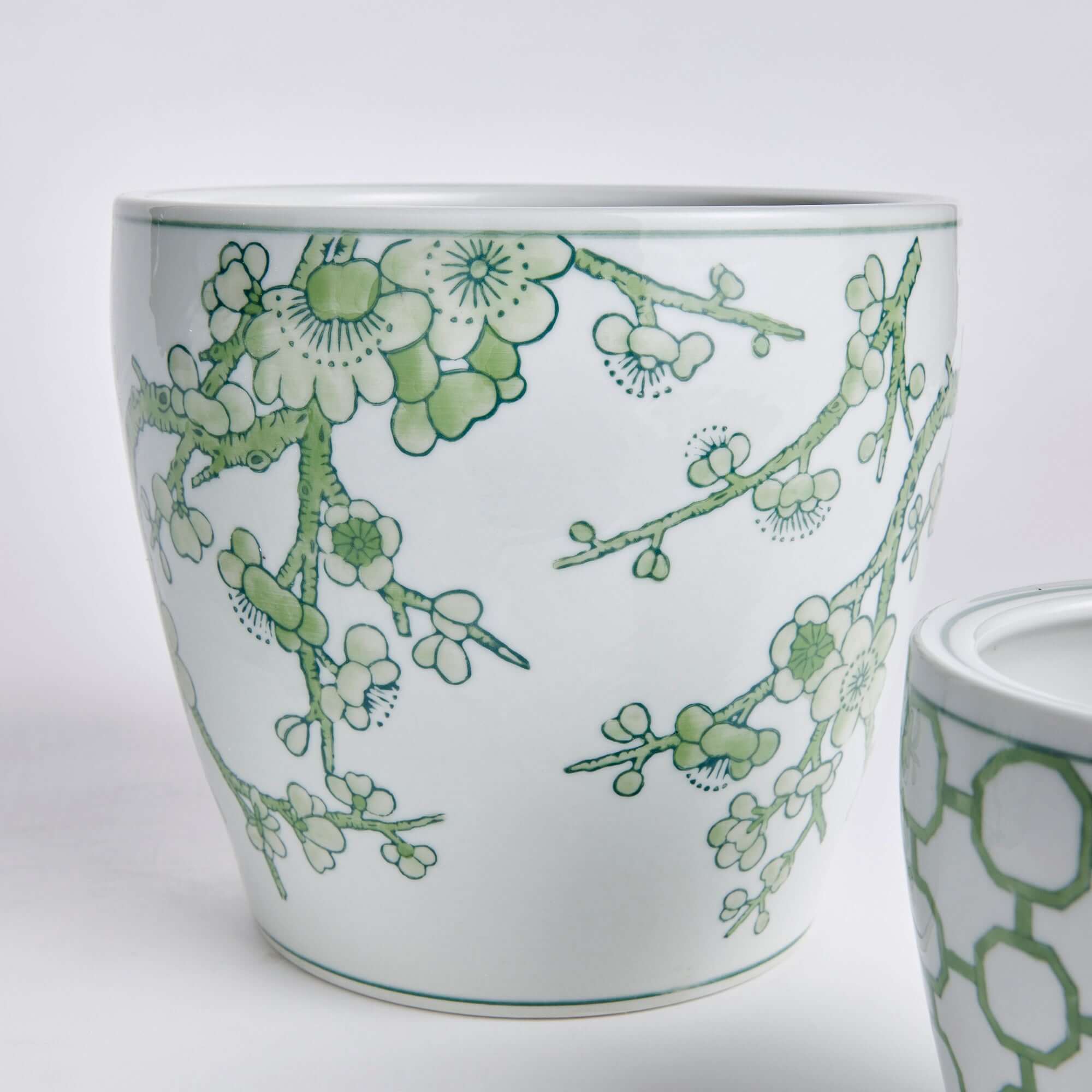 White planter with green floral design on a white background