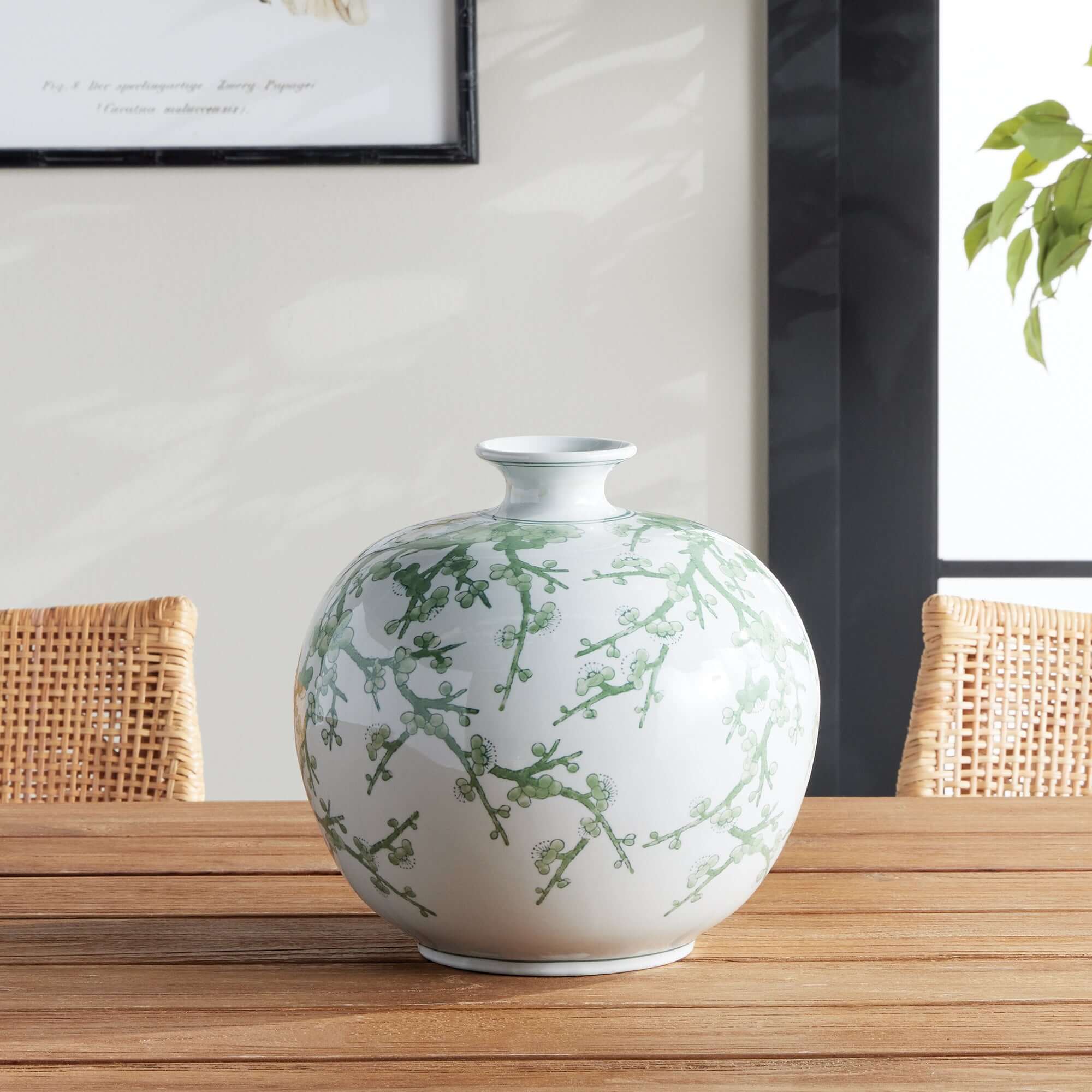 Decorative vase with green floral patterns on a wooden table