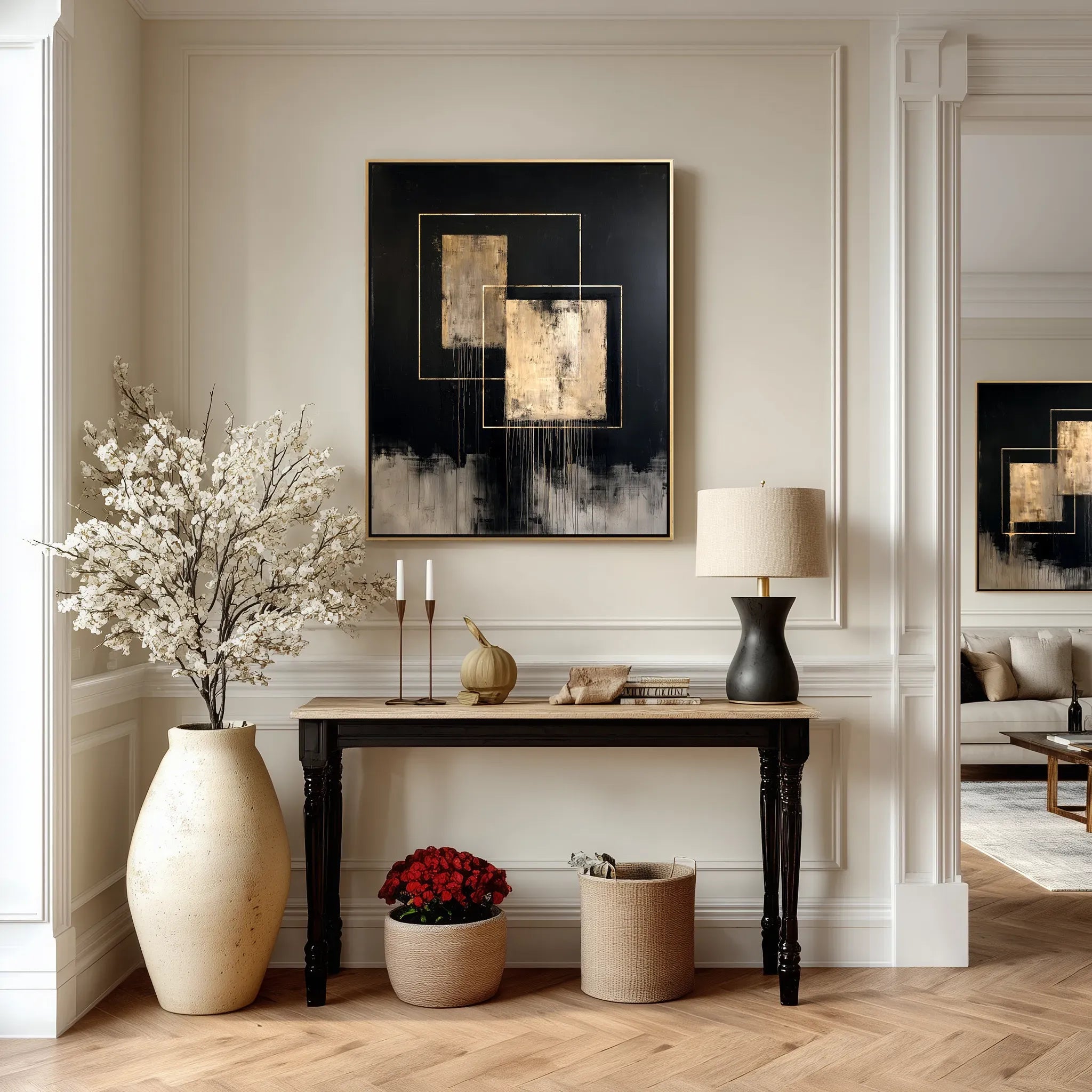 Luxury interior featuring a black abstract canvas with gold-toned accents displayed above a black console table, styled with neutral décor, sculptural ceramics, and soft modern lighting.