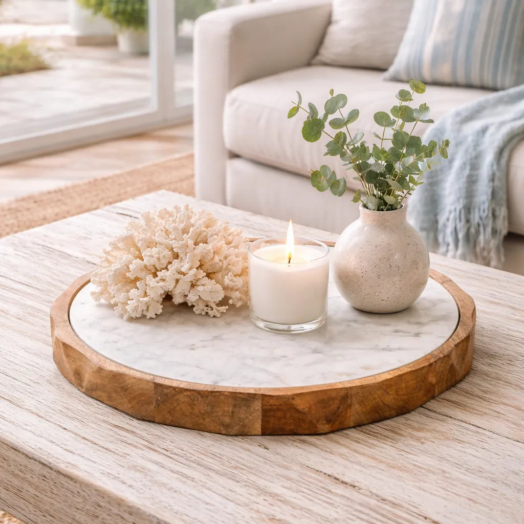 Decorative tray with coral, candle, and vase on a coffee table in a living room.