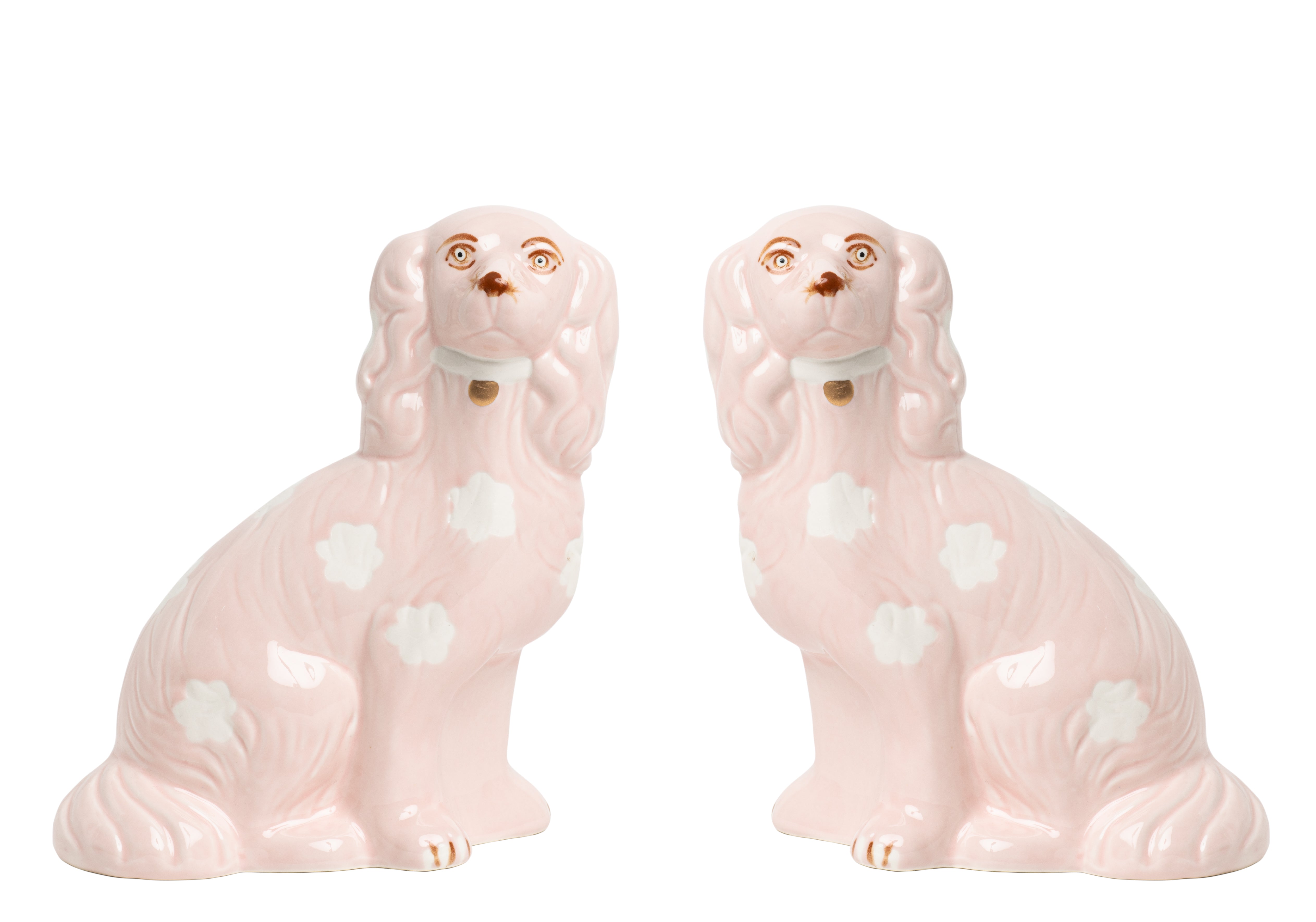 Two pink ceramic dog figurines on a white background
