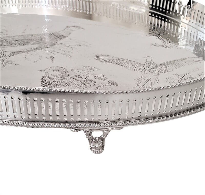 Decorative silver platter with intricate designs on a white background