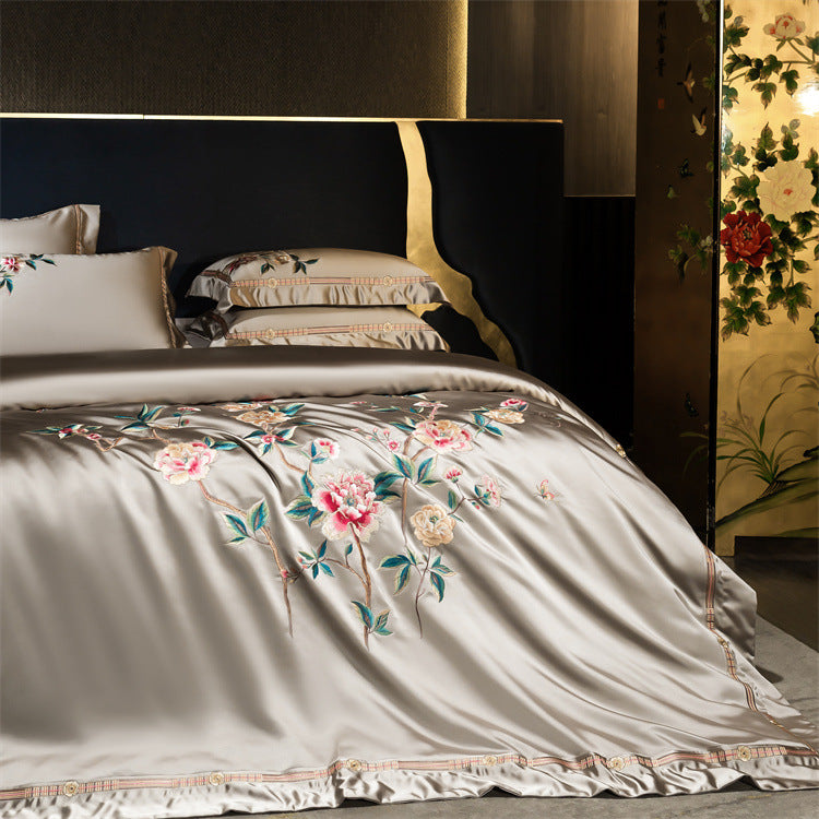 Floral embroidered bedding set on a bed with a decorative headboard.