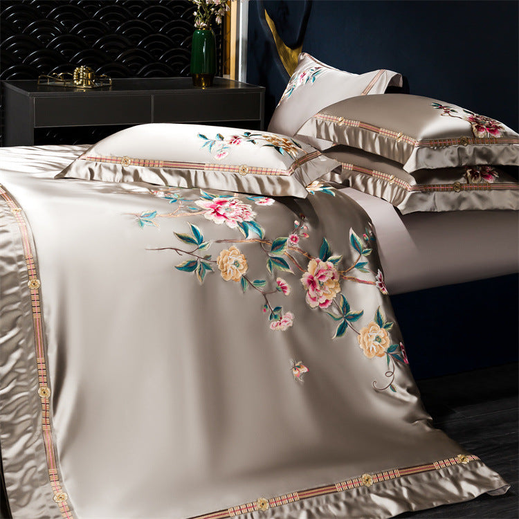 Floral embroidered bedding set on a bed with a dark background