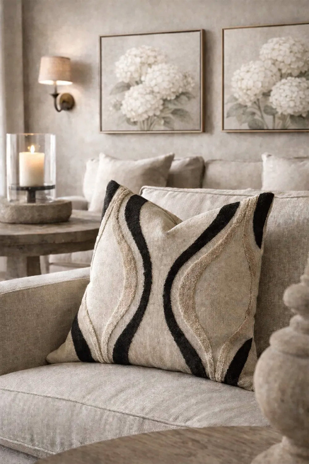 Decorative pillow on a couch with floral artwork in the background