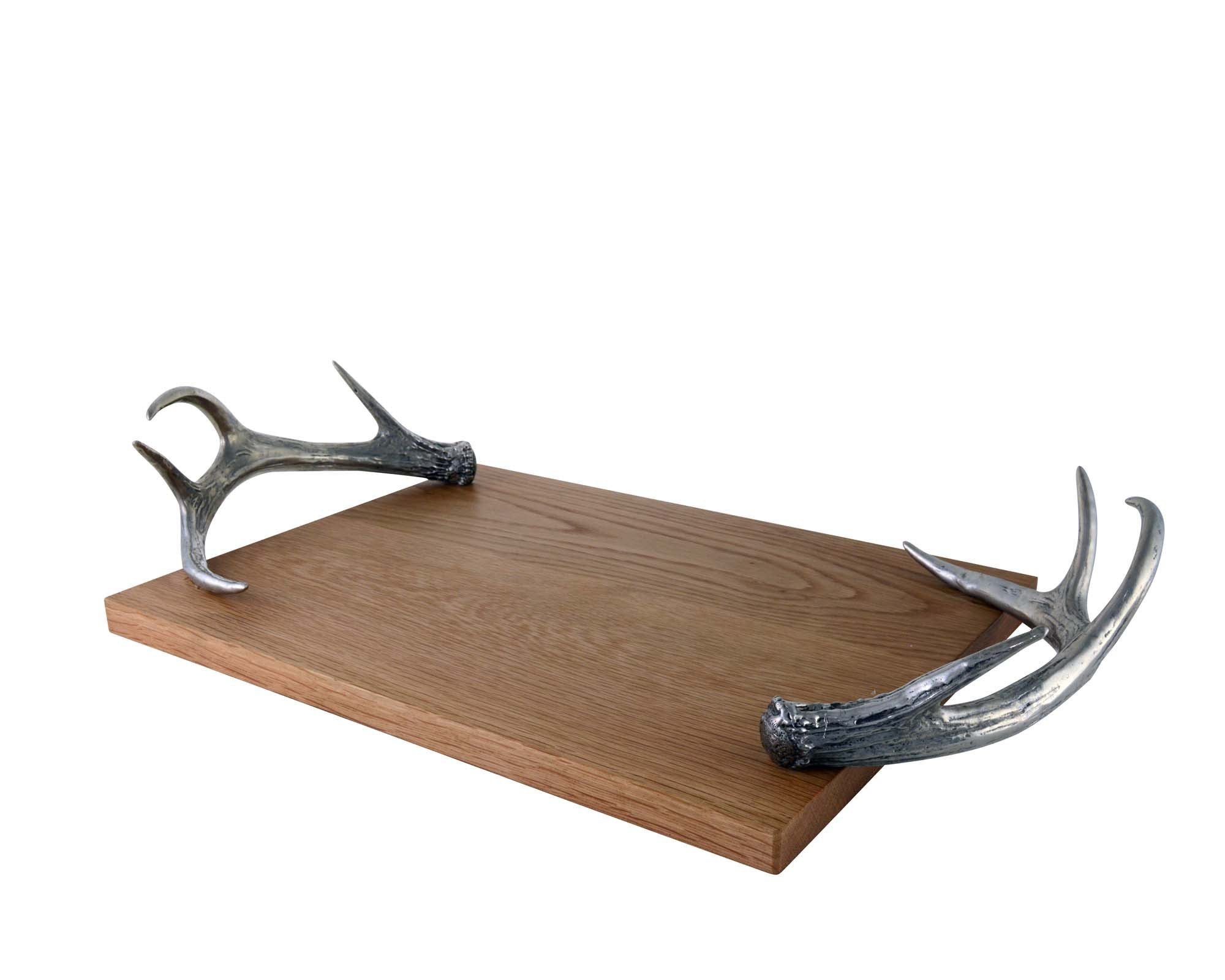 Side angle of a wooden tray with pewter antler handles on a white background